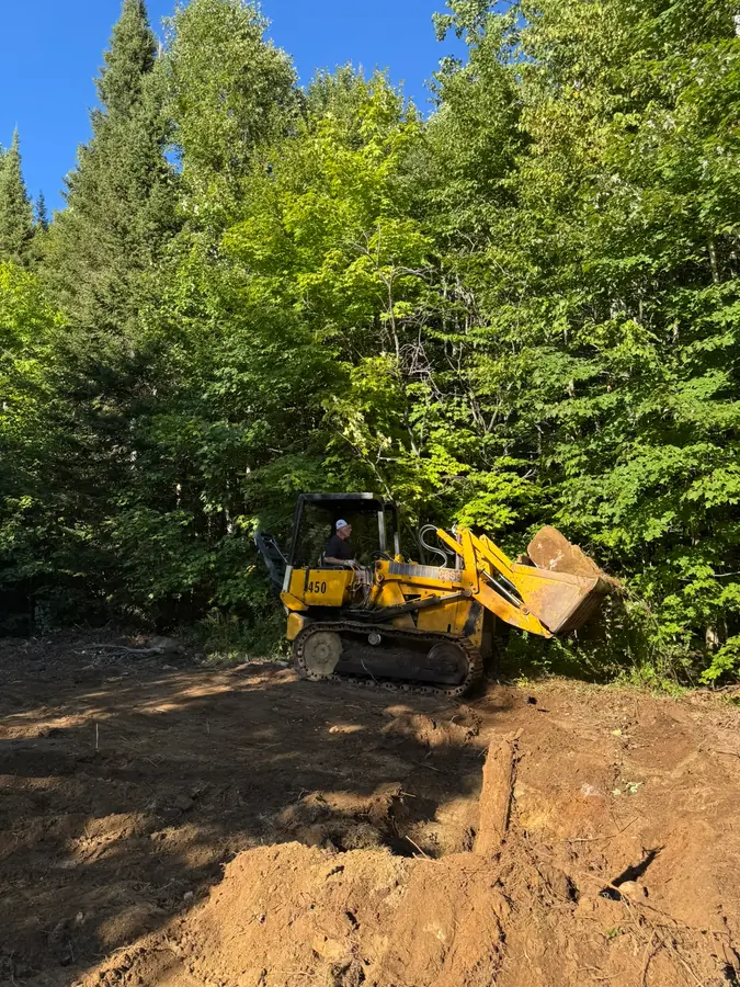 Le père de Carl déterrant d'énormes roches sur le site du mariage.